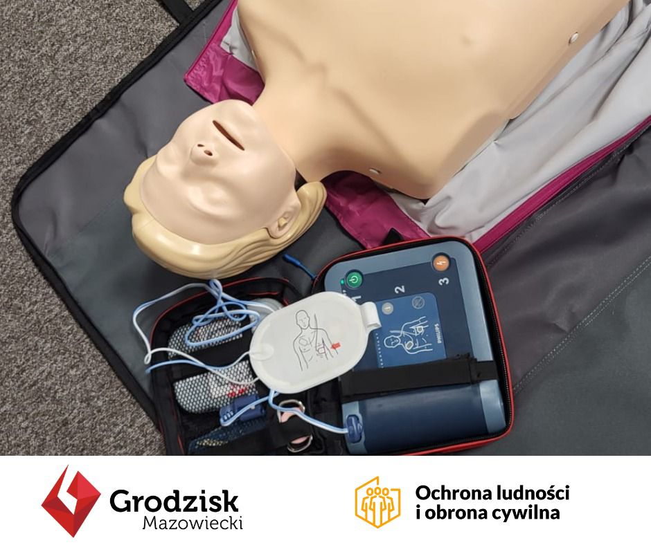 Zdjęcie manekina szkoleniowego do ćwiczenia resuscytacji z umieszczonym obok urządzeniem AED